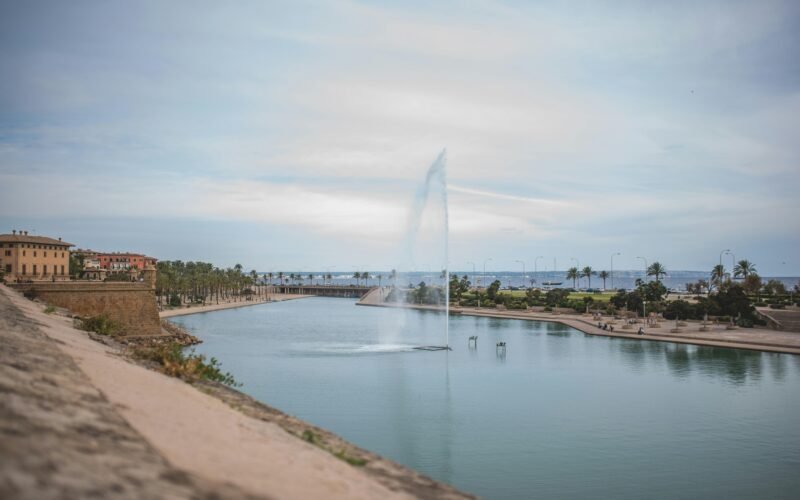 Große Wasserfläche mit einer Fontäne in der Mitte auf Mallorca, fotografiert von Monika Guzikowska.