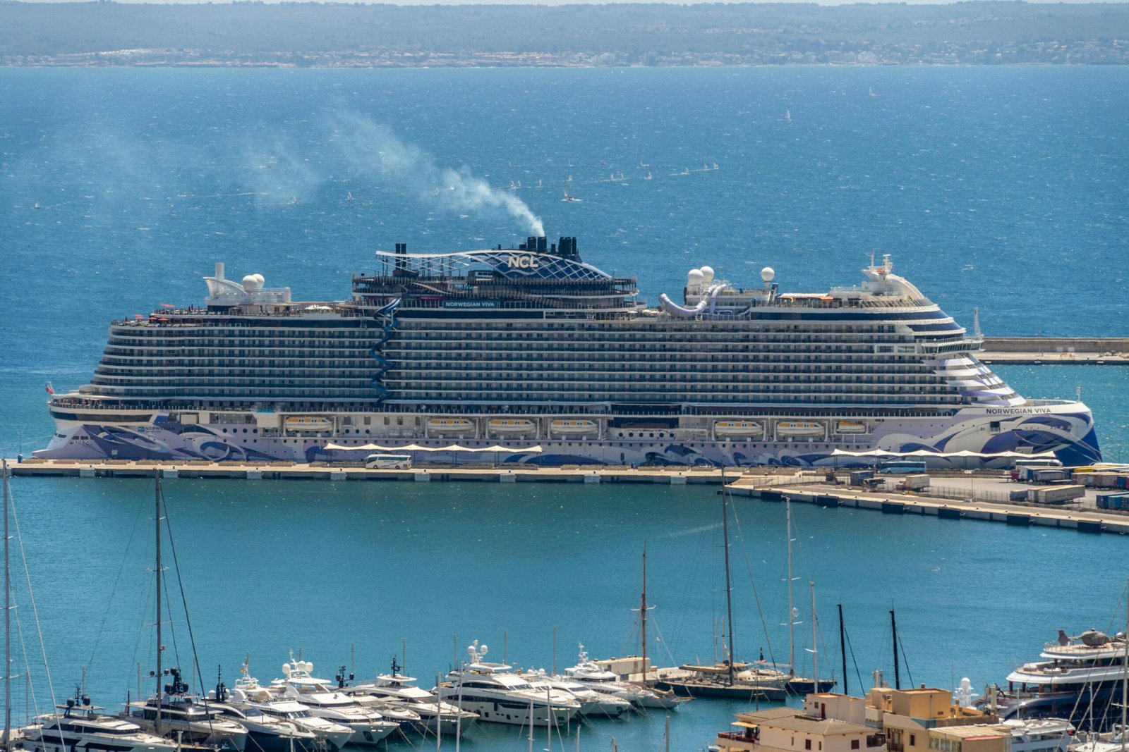 Großes Kreuzfahrtschiff im Hafen auf Mallorca, festgemacht an den Anlegestellen, mit Blick auf das Wasser und den Himmel.