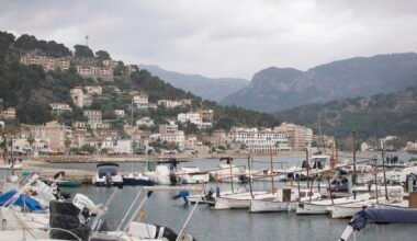 Mehrere Boote liegen in stiller Wasserfläche auf Mallorca, aufgenommen von Anna Wohnoutka.