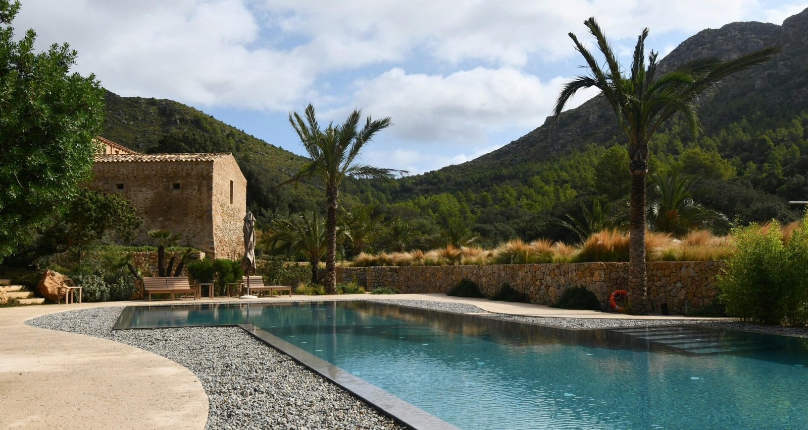 Haus mit Pool auf Mallorca im mediterranen Stil, umgeben von Garten und Sonnenschein