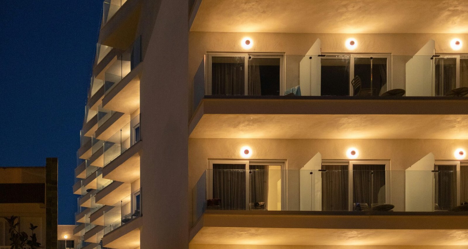 Hochhaus mit vielen beleuchteten Balkonen bei Nacht auf Mallorca, aufgenommen von Elena Soroka