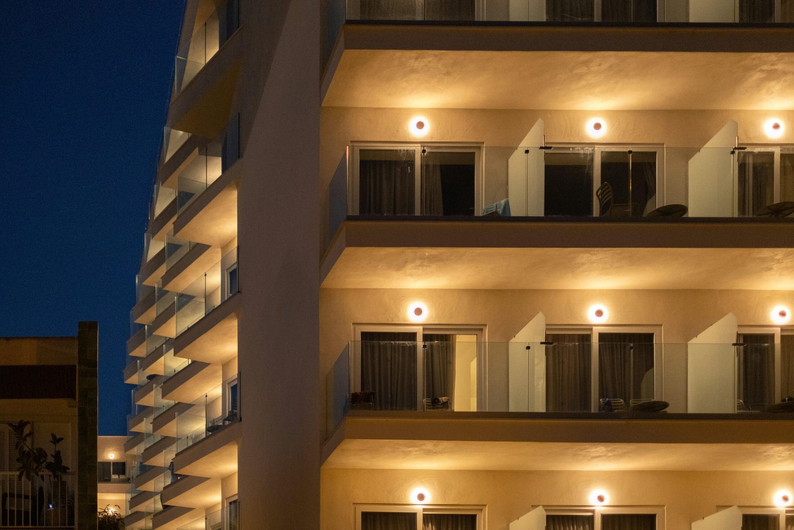 Hochhaus mit zahlreichen beleuchteten Balkonen bei Nacht auf Mallorca, aufgenommen von Elena Soroka