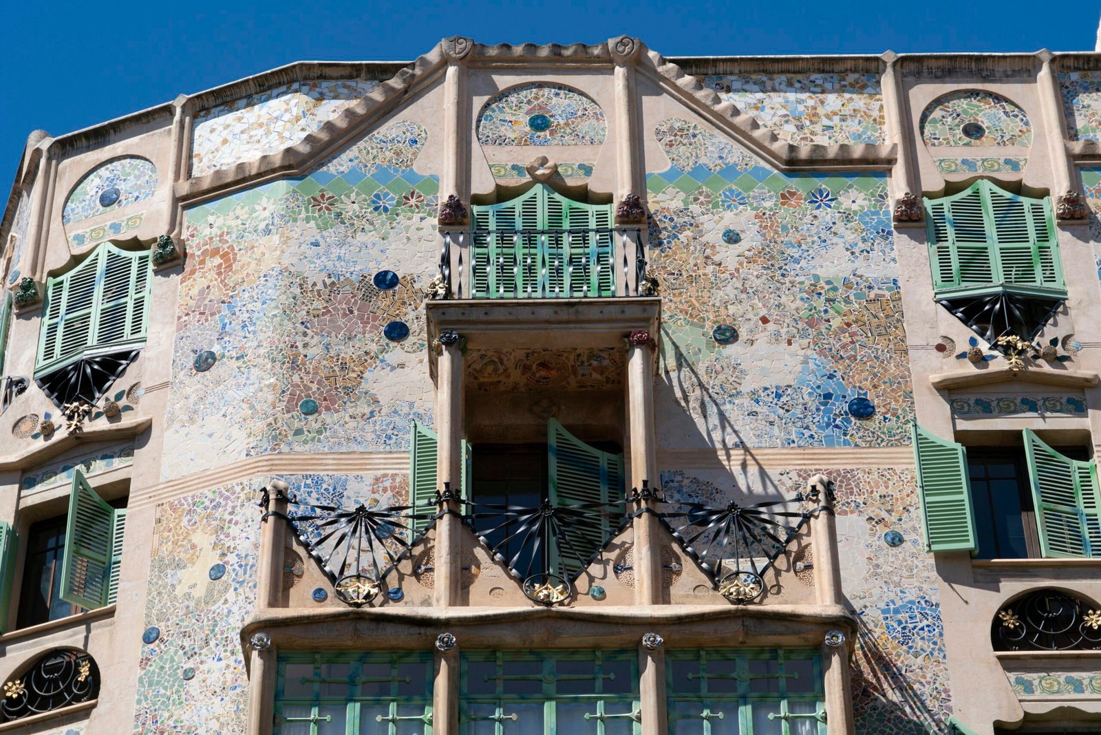 Hohes Gebäude mit vielen Fenstern und grünen Fensterläden auf Mallorca, fotografiert von Marian Florinel Condruz