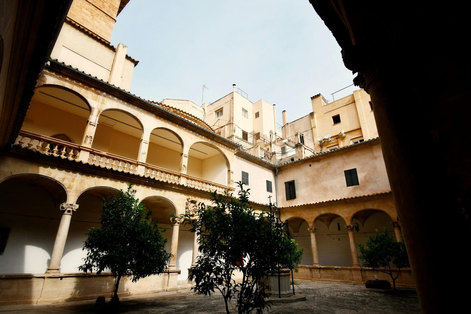 Innenhof mit Baum in der Mitte auf Mallorca, fotografiert von Max Harlynking, zeigt eine ruhige und authentische Szene.