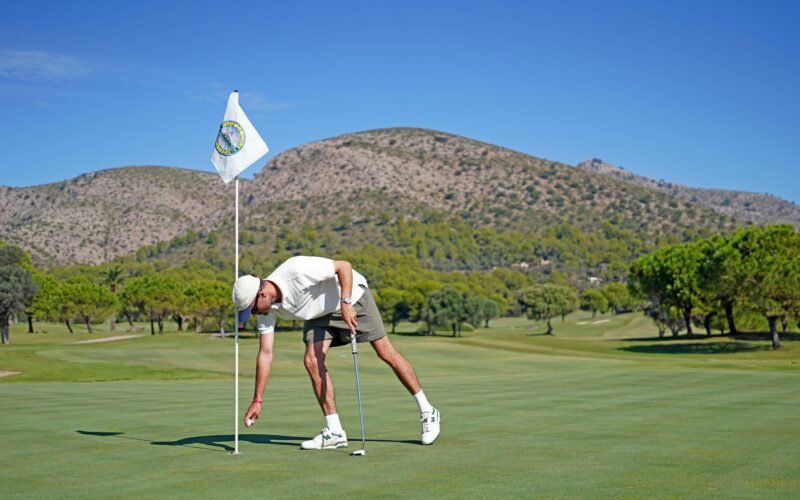 Mann beim Putten auf dem Golfplatz auf Mallorca, Frederik Rosar