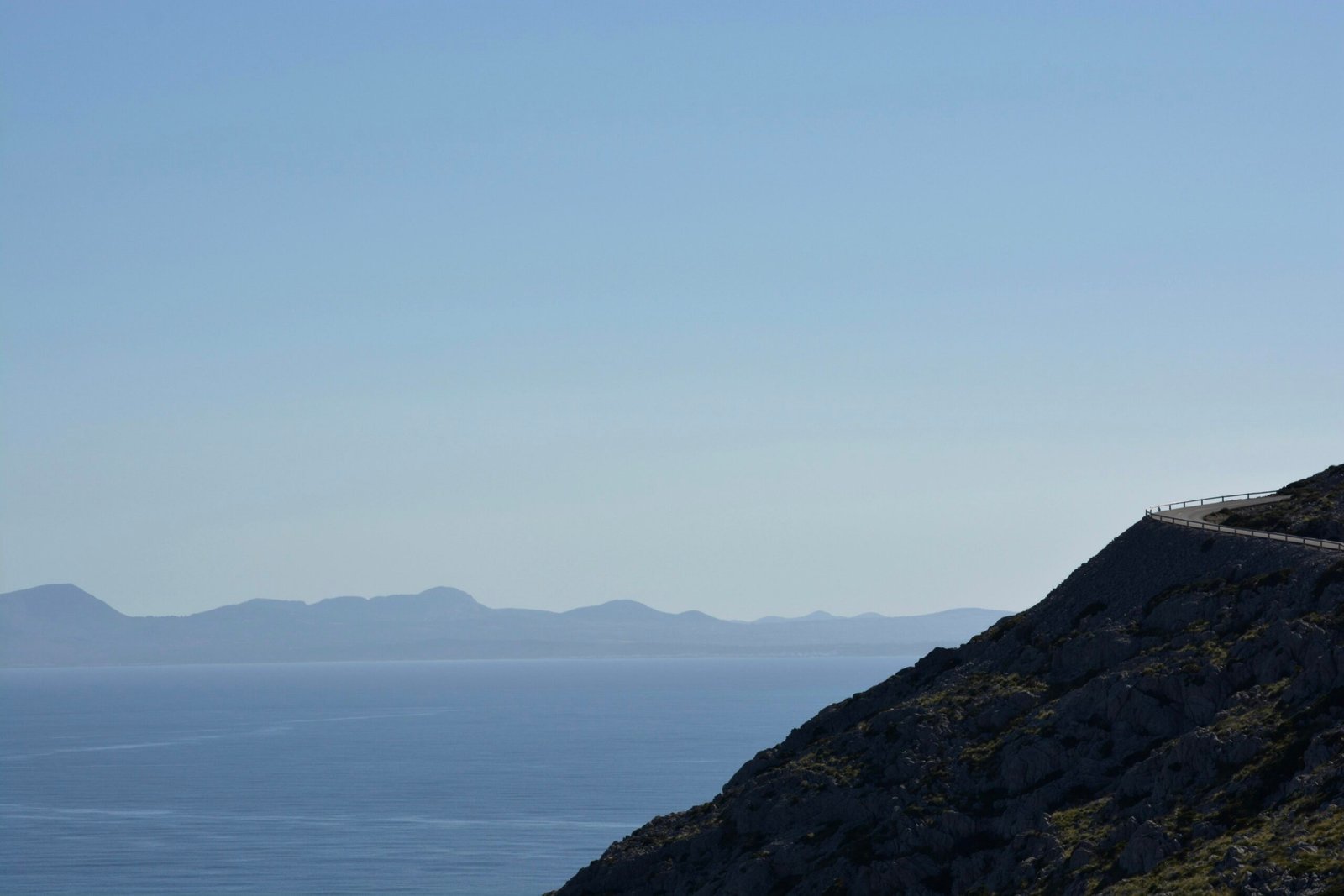 Mann auf Mallorca fährt mit dem Motorrad einen Hügel hinunter, umgeben von natürlicher Landschaft.
