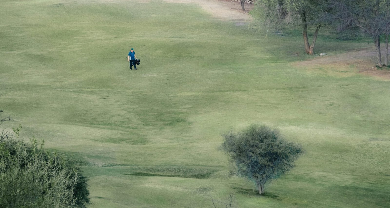 Mann reitet auf einem Pferd durch ein grünes Feld auf Mallorca, aufgenommen von Mariano Baraldi.