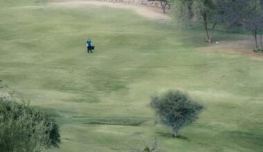 Mann reitet auf einem Pferd durch ein grünes Feld auf Mallorca, aufgenommen von Mariano Baraldi.