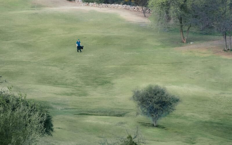 Mann reitet auf einem Pferd durch ein grünes Feld auf Mallorca, aufgenommen von Mariano Baraldi.
