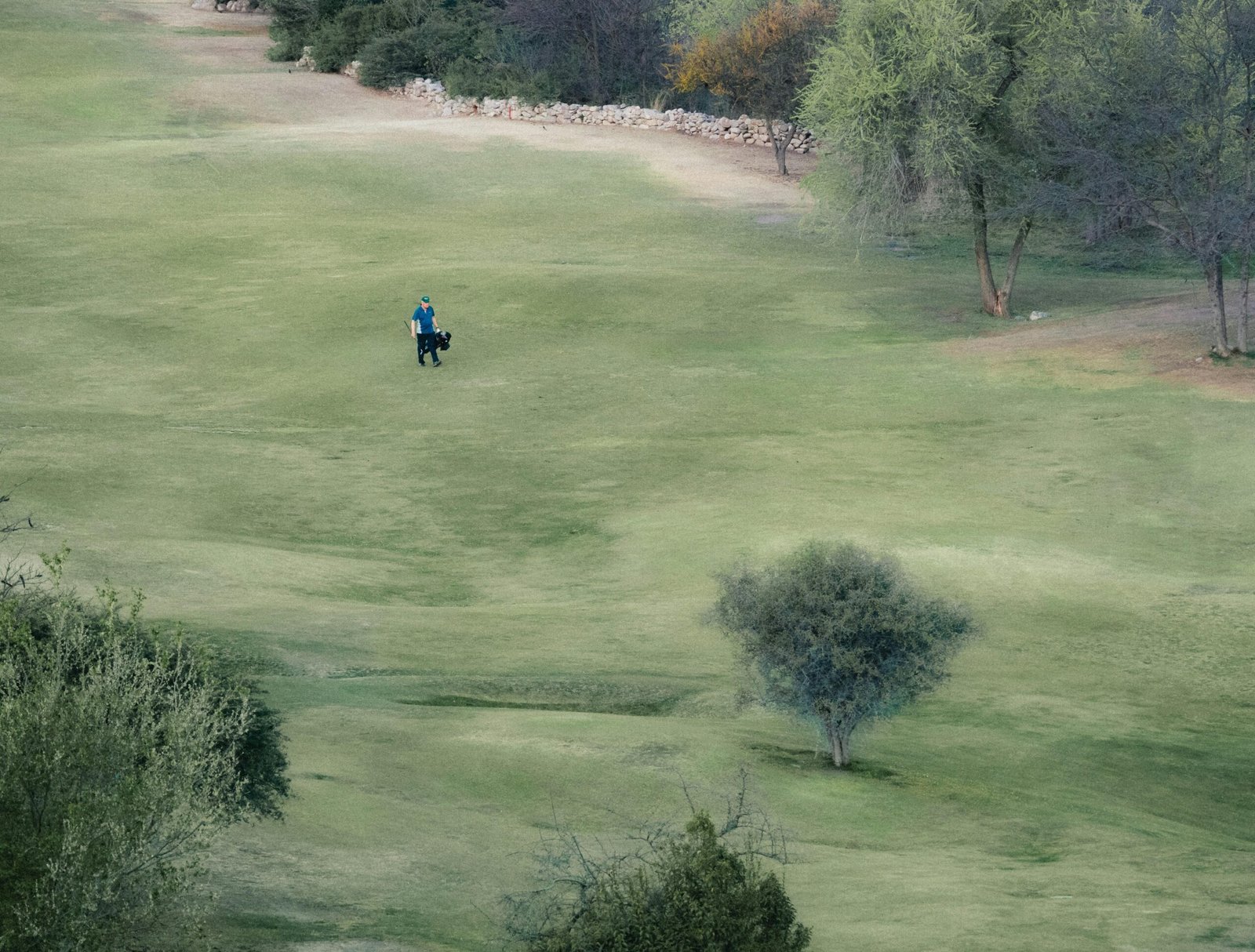 Mann reitet auf einem Pferd durch ein grünes Feld auf Mallorca, aufgenommen von Mariano Baraldi.