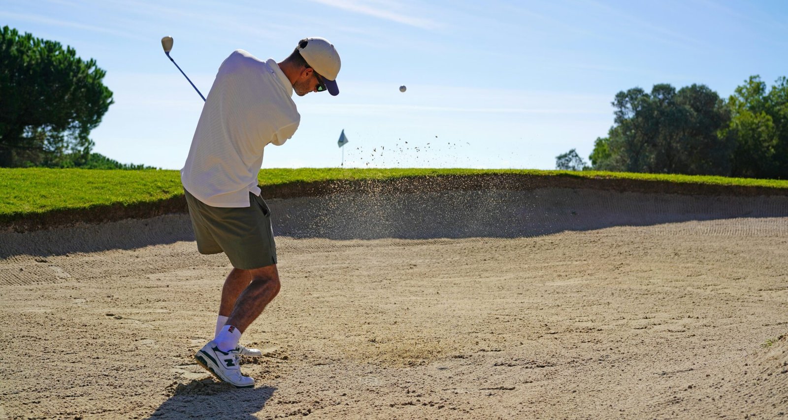 Mann spielt Golf auf Mallorca an einem sonnigen Tag, umgeben von grünem Rasen und mediterraner Landschaft