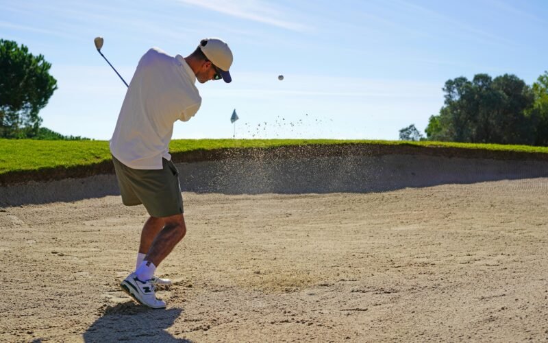 Mann spielt Golf auf Mallorca an einem sonnigen Tag, umgeben von grünem Rasen und mediterraner Landschaft