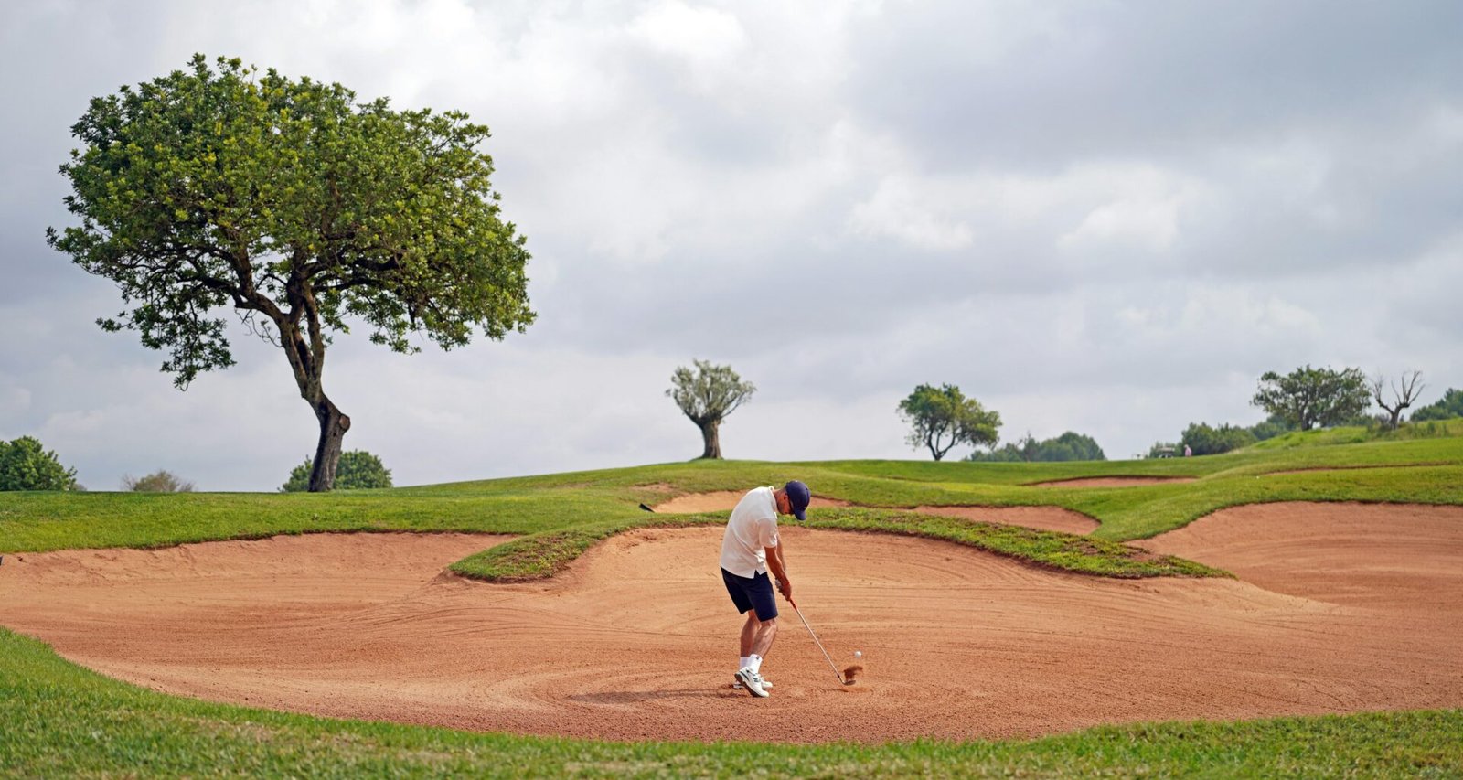 Mann beim Golfspielen auf Mallorca auf einem grünen Golfplatz, fotografiert von Frederik Rosar