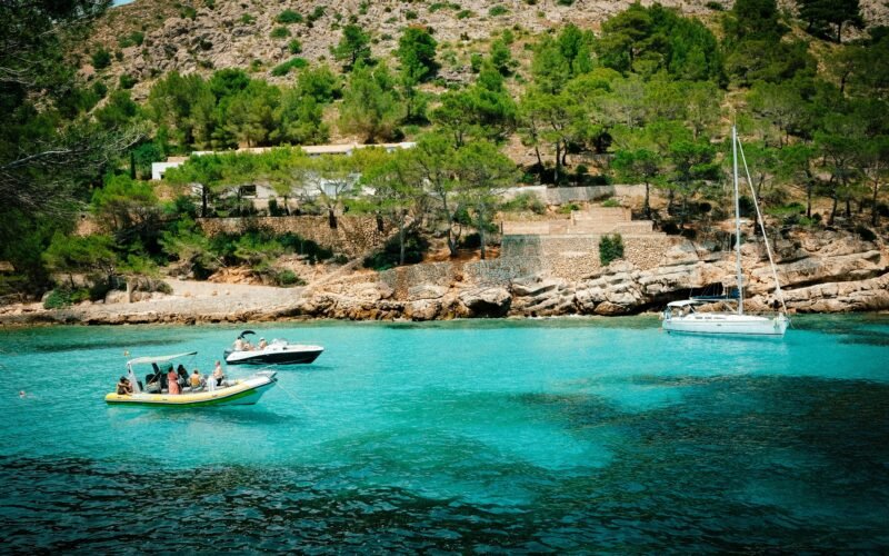 Mehrere Boote liegen im Wasser auf Mallorca, fotografiert von Luke Moss.