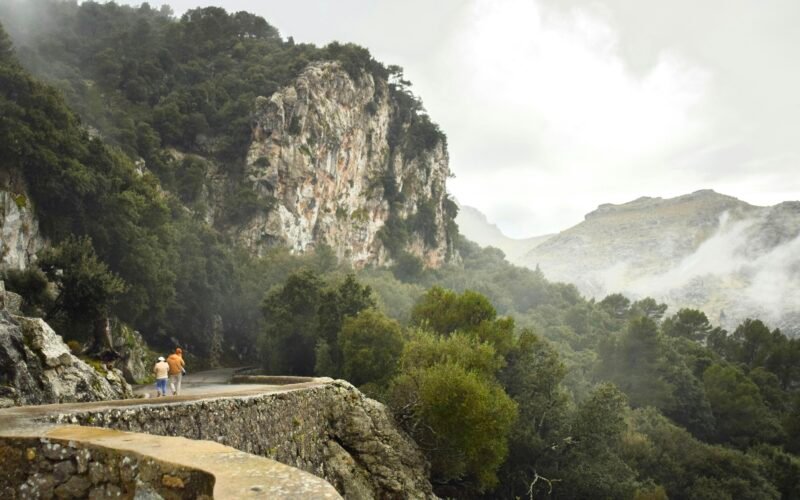 Paar von Menschen beim Spaziergang auf einer Straße auf Mallorca, umgeben von natürlicher Landschaft