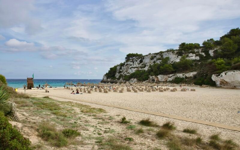 Sandstrand auf Mallorca neben dem Ozean unter einem bewölkten Himmel, aufgenommen von Stock Birken