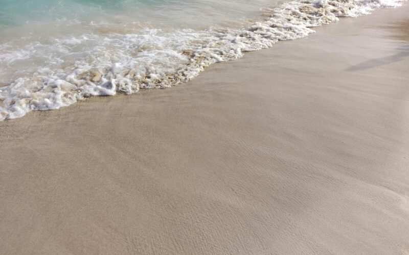 Sandstrand auf Mallorca mit Wellen, aufgenommen von Mauro Leoni, zeigt die Küstenlinie und das Meer