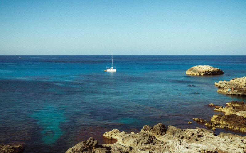 Segelboot auf Mallorca, das in der türkisfarbenen Meeresoberfläche treibt, aufgenommen von Polina Cherkasova.