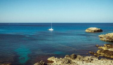 Segelboot treibt auf Mallorca in den klaren, türkisfarbenen Gewässern des Meeres, aufgenommen von Polina Cherkasova.