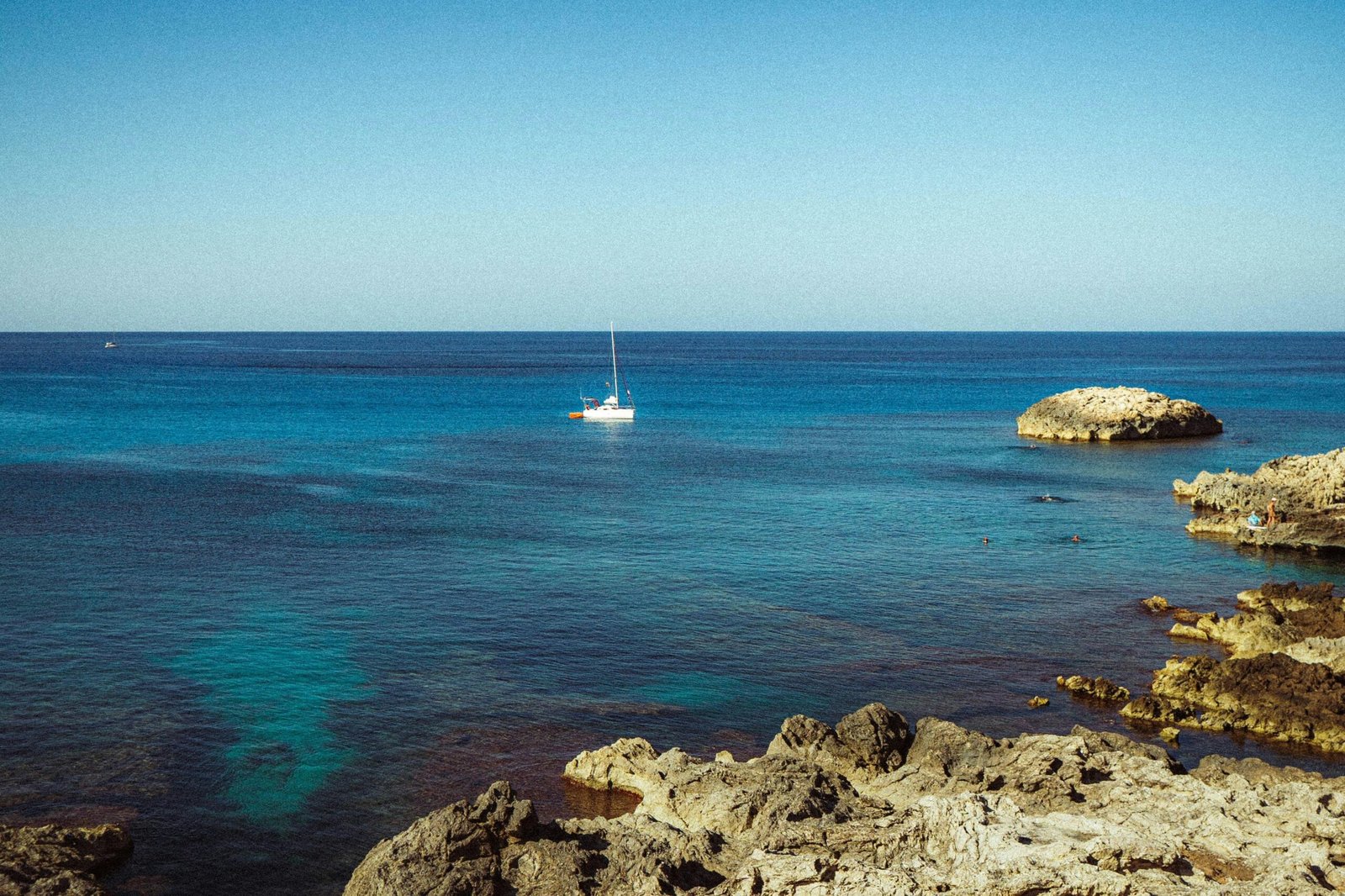 Segelboot treibt auf dem türkisen Wasser auf Mallorca, aufgenommen von Polina Cherkasova.