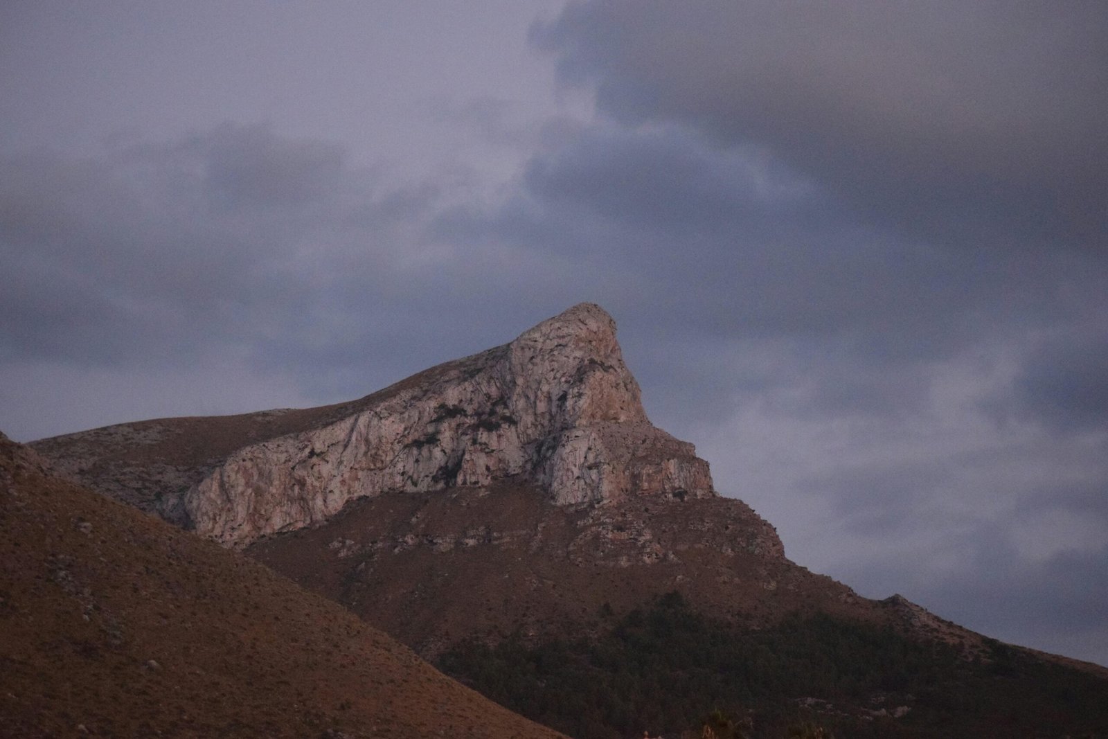 Hoch aufragender Berg auf Mallorca mit bewölktem Himmel im Hintergrund, fotografiert von Jannik.