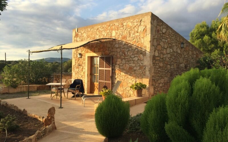 Steinernes Gebäude mit Terrasse und Sonnenschirm auf Mallorca, aufgenommen von Sara Sadeghloo.