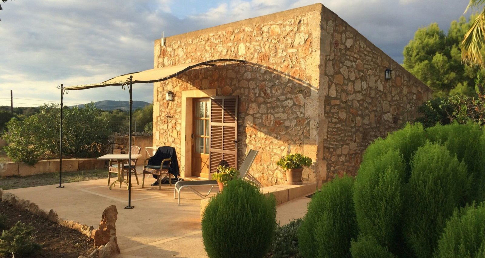 Steinernes Gebäude mit Terrasse und Sonnenschirm auf Mallorca, fotografiert von Sara Sadeghloo