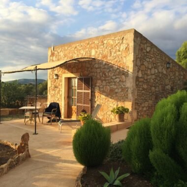 Steinernes Gebäude mit Terrasse und Sonnenschirm auf Mallorca, fotografiert von Sara Sadeghloo