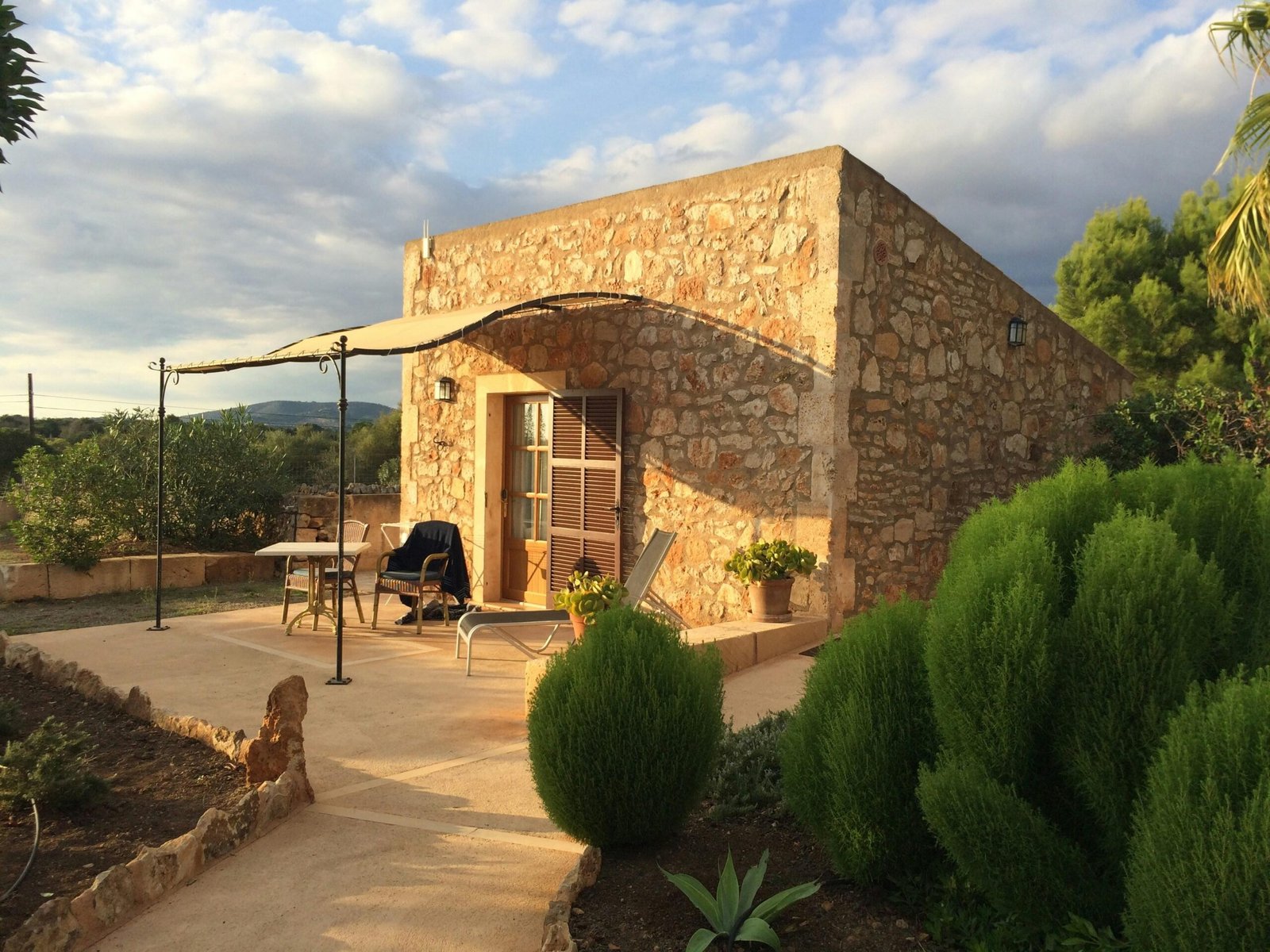 Steingebäude mit Terrasse und Sonnenschirm auf Mallorca, aufgenommen von Sara Sadeghloo