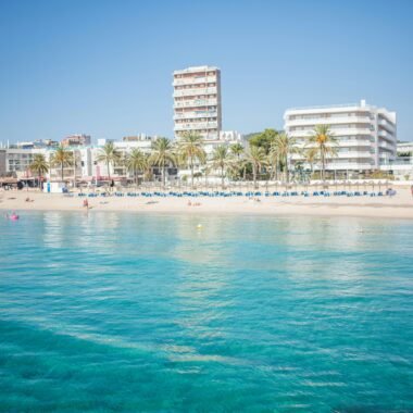 Strand auf Mallorca mit Gebäuden im Hintergrund, aufgenommen von Monika Guzikowska