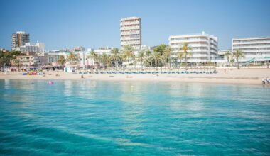 Strand auf Mallorca mit Gebäuden im Hintergrund, aufgenommen von Monika Guzikowska