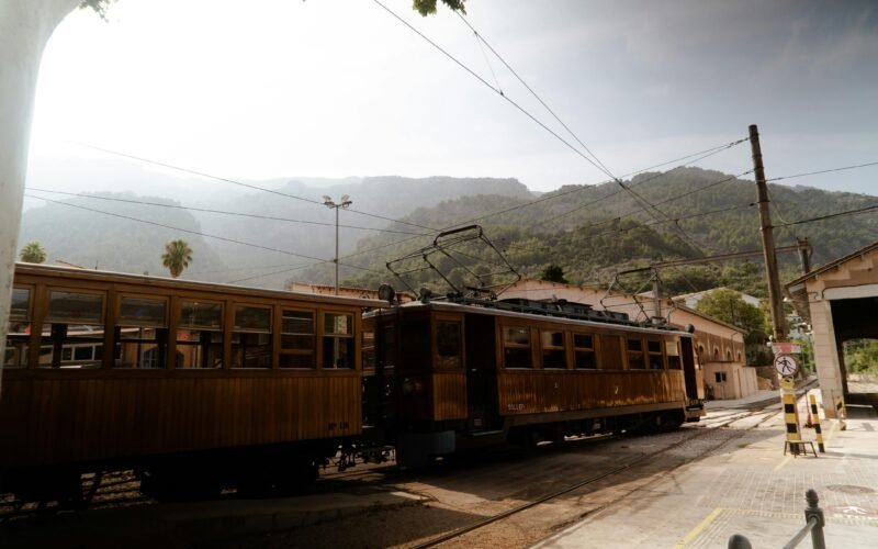 Ein Zug fährt auf Mallorca entlang der Bahnstrecke neben Bergen, aufgenommen von Victor Oonk.