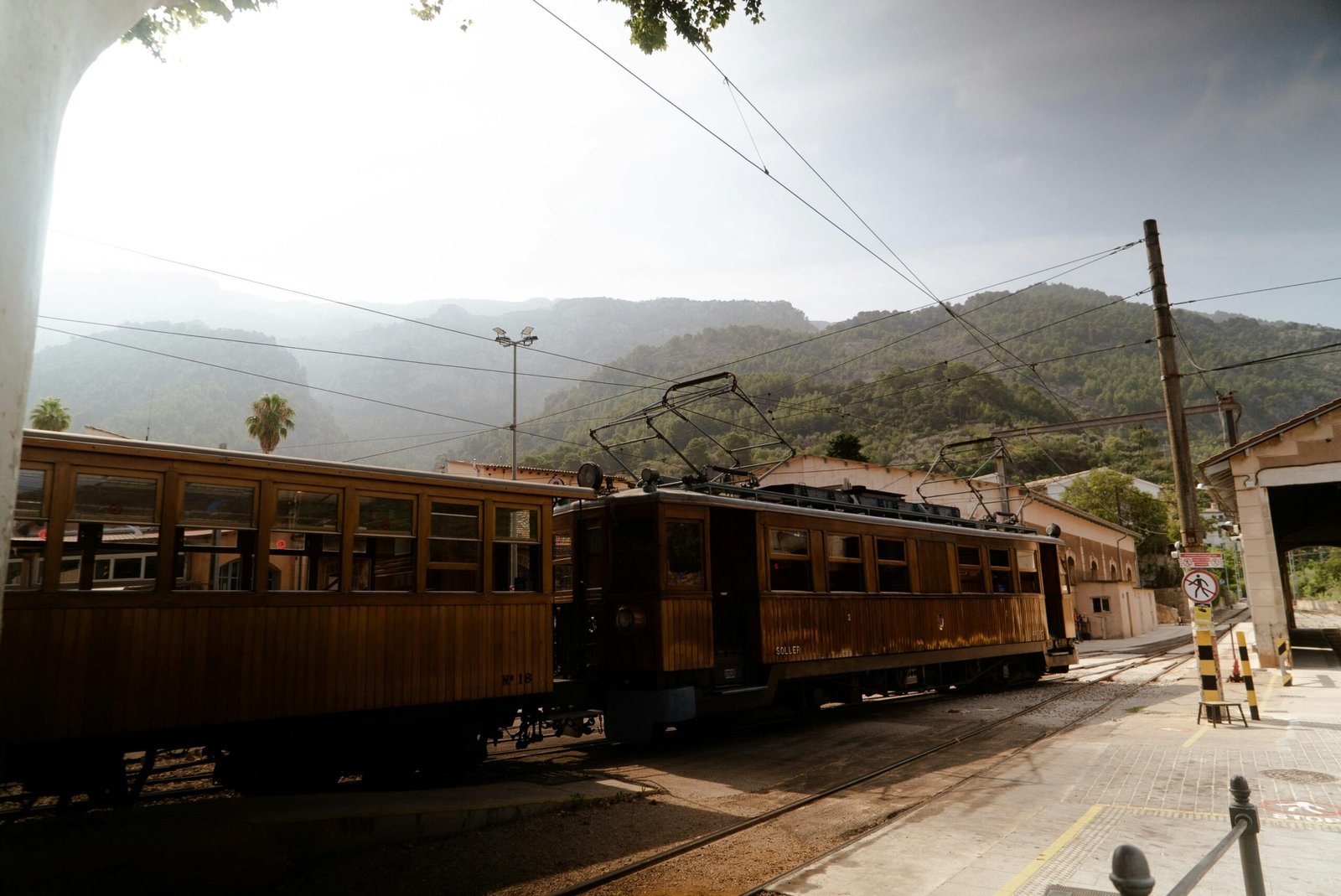 Ein Zug fährt auf Mallorca entlang der Bahngleise neben einer Berglandschaft, aufgenommen von Victor Oonk.