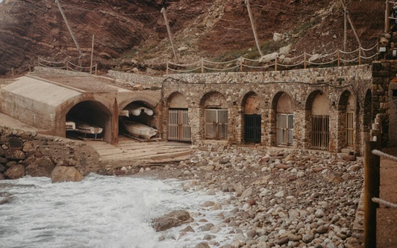 Felsige Klippe auf Mallorca mit Wasser im Vordergrund, fotografiert von Raymond Petrik