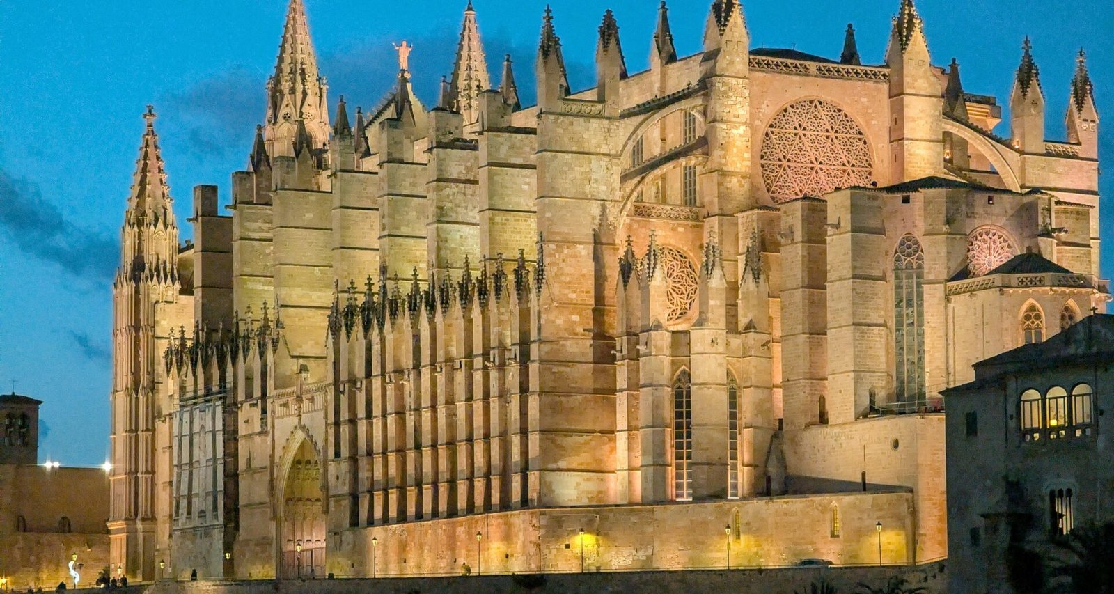 Große Kathedrale auf Mallorca, beleuchtet bei Dämmerung, mit beeindruckender Architektur und warmem Licht
