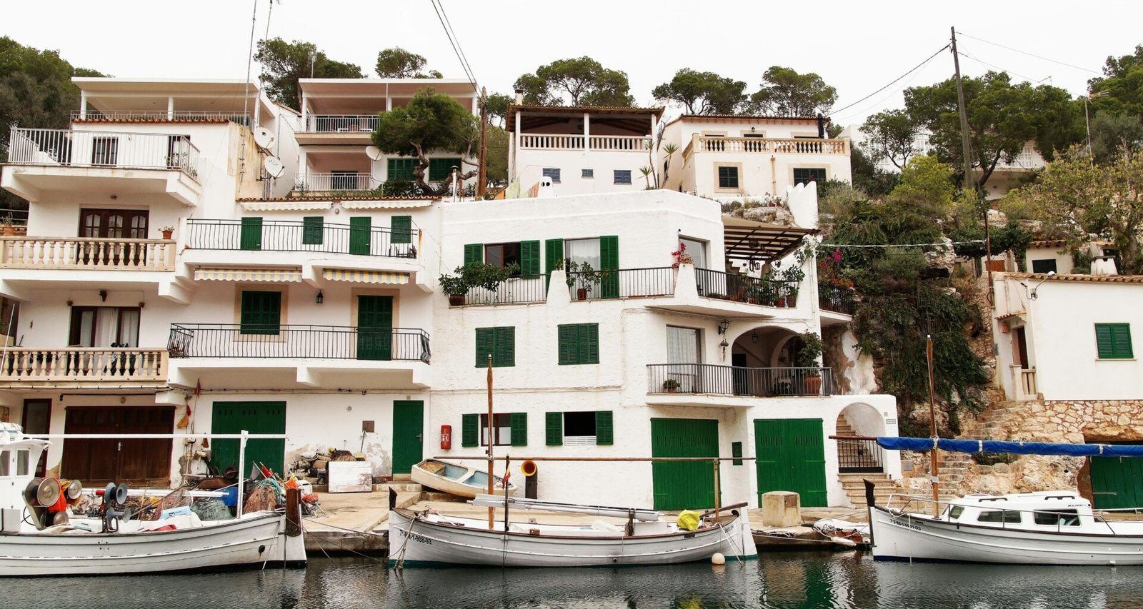 Mehrere Boote liegen nebeneinander auf Mallorca am Wasser, aufgenommen von Alex Kulikov.