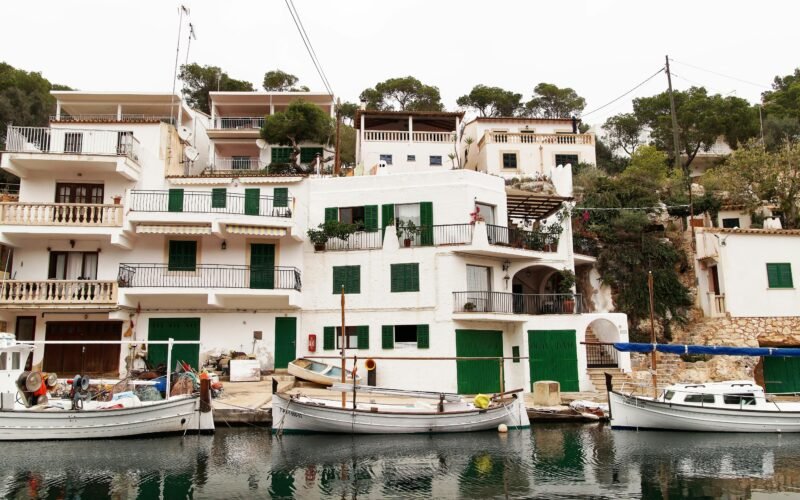 Mehrere Boote liegen nebeneinander auf Mallorca auf dem Wasser, aufgenommen von Alex Kulikov.