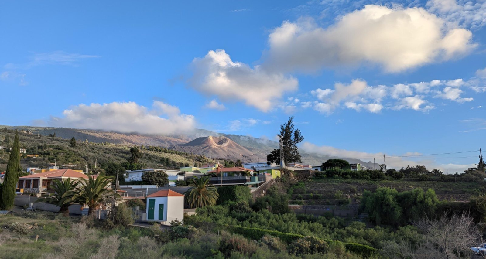 Mehrere Häuser in einem Tal auf Mallorca, umgeben von grüner Natur und Bergen, aufgenommen von Federico Mata.