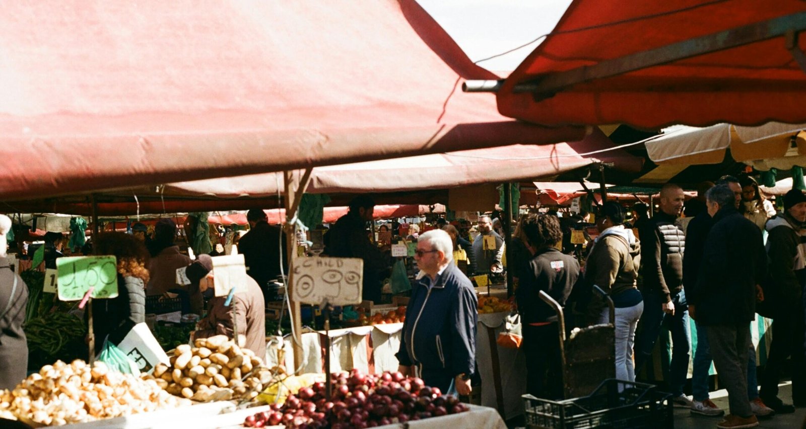 Gruppe von Menschen beim Einkaufen auf einem Markt auf Mallorca, Stände mit frischen Produkten