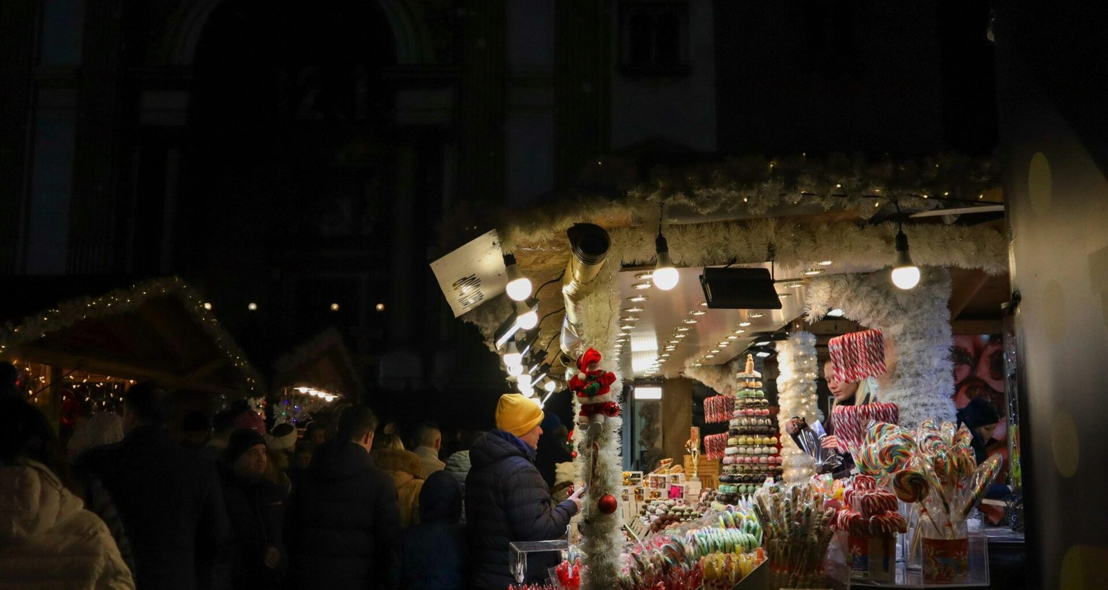Gruppe von Menschen steht draußen vor einem Laden bei Nacht auf Mallorca, aufgenommen von Viola Kovács.