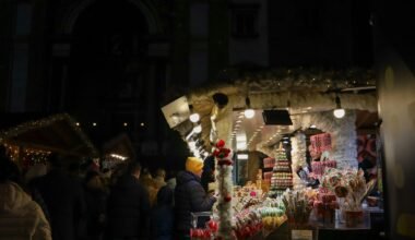 Gruppe von Menschen steht draußen vor einem Laden bei Nacht auf Mallorca, aufgenommen von Viola Kovács.