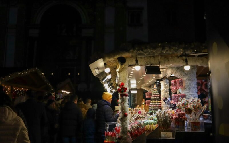 Gruppe von Menschen steht draußen vor einem Laden bei Nacht auf Mallorca, aufgenommen von Viola Kovács.