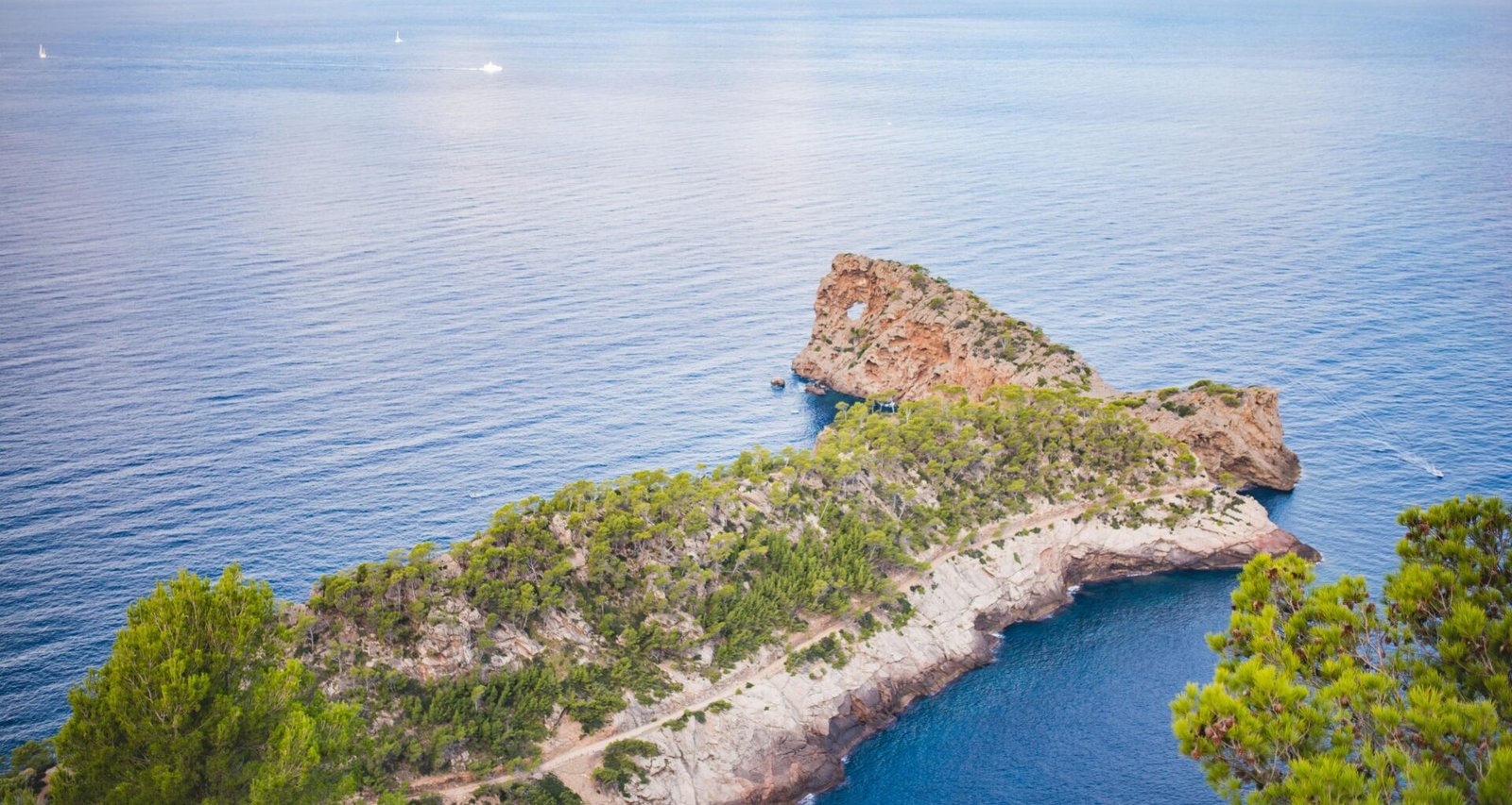 Kleine Insel inmitten des Ozeans auf Mallorca, fotografiert von Monika Guzikowska, zeigt die unberührte Natur und das klare Wasser.