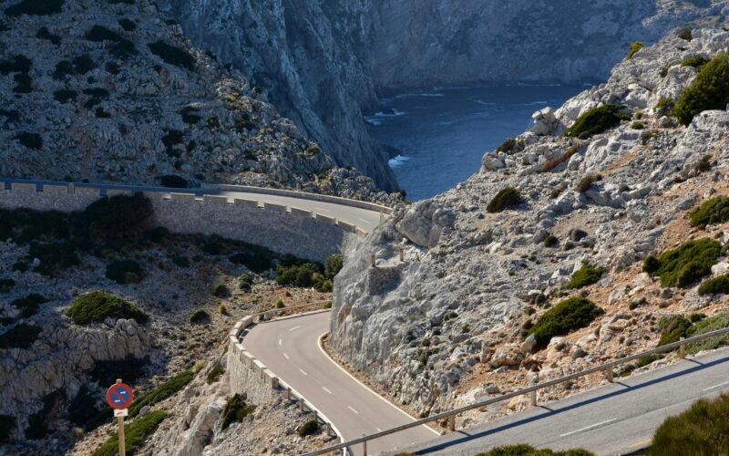 Winding road on the side of a mountain auf Mallorca, umgeben von Natur und Felsen