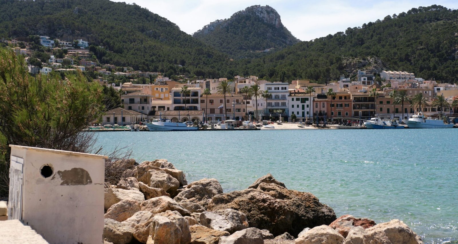 Szenische Ansicht eines Küstenstädtchens auf Mallorca am ruhigen Meer, aufgenommen von Tim Schmidbauer.