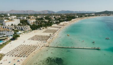 Pitoreske Strandkulisse auf Mallorca mit Touristen, Sand und Gebäuden, aufgenommen von Tomas Eidsvold.