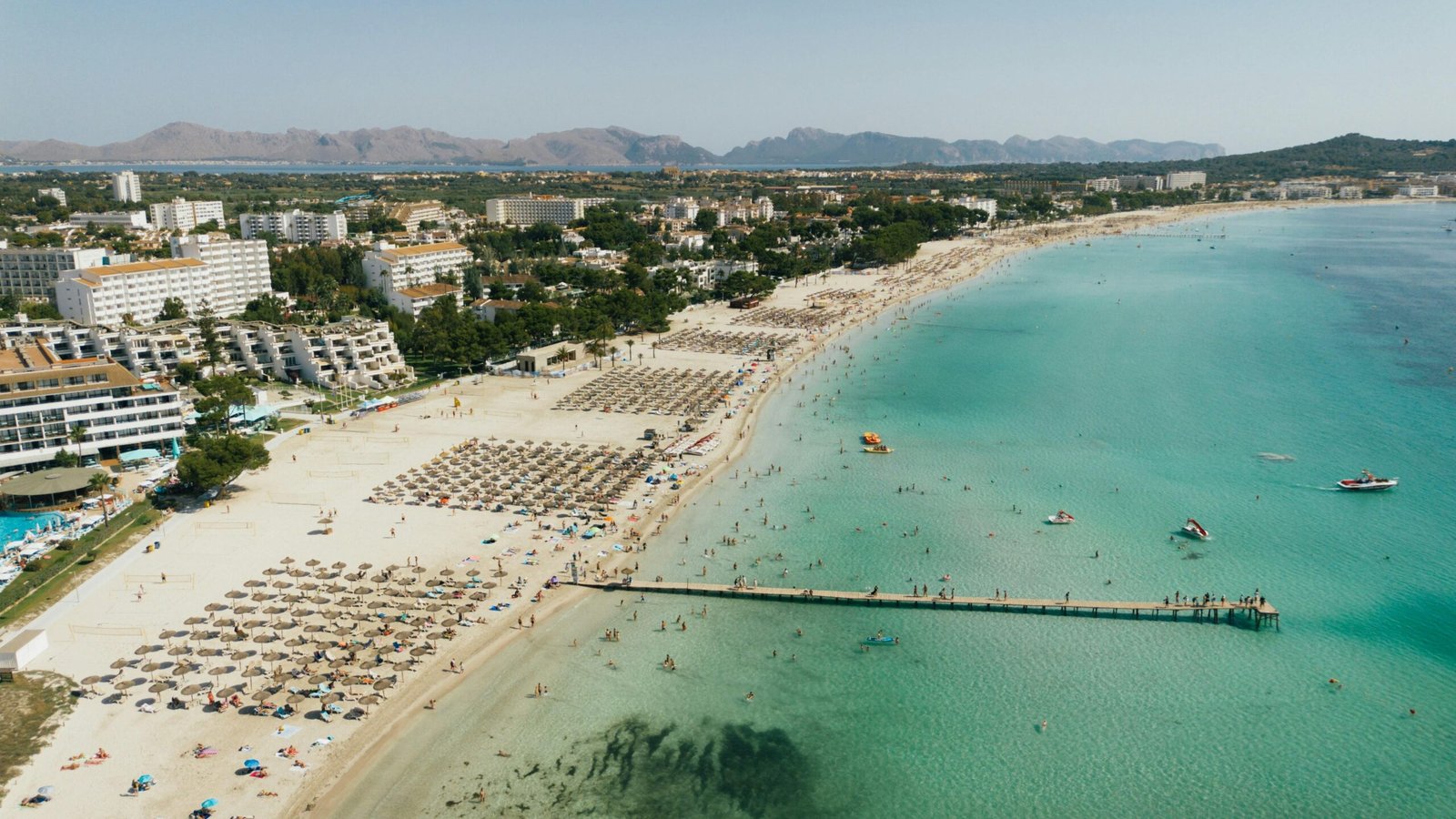 Pitoreske Strandkulisse auf Mallorca mit Touristen, Sand und Gebäuden, aufgenommen von Tomas Eidsvold.