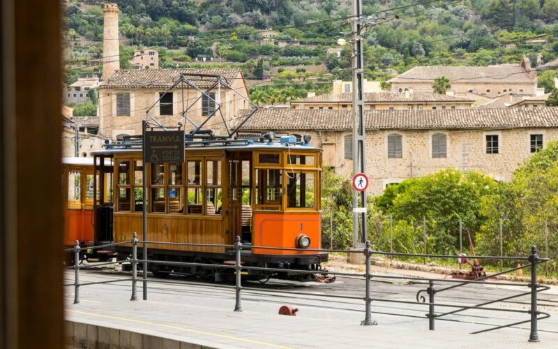 Oranger Trolley fährt die Straße entlang auf Mallorca, aufgenommen von Artur Łuczka.