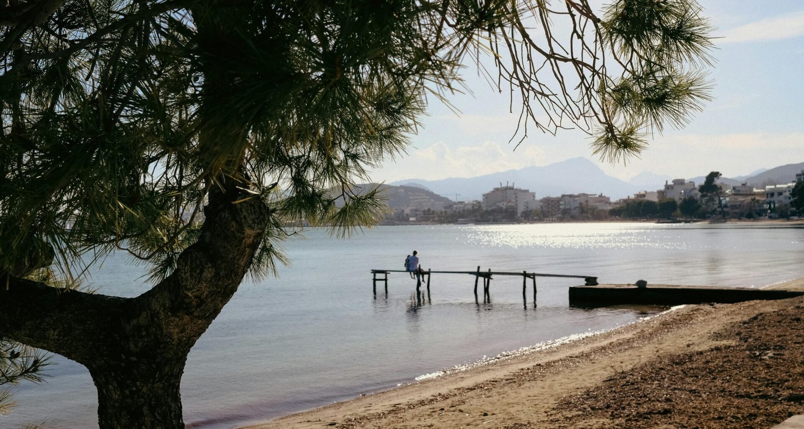 Person steht auf einem Steg im Wasser auf Mallorca, aufgenommen von Konstantin Chemeris, mit Blick aufs Wasser und die Natur