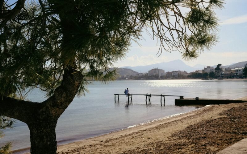 Person steht auf einem Steg im Wasser auf Mallorca, aufgenommen von Konstantin Chemeris, mit Blick aufs Wasser und die Natur
